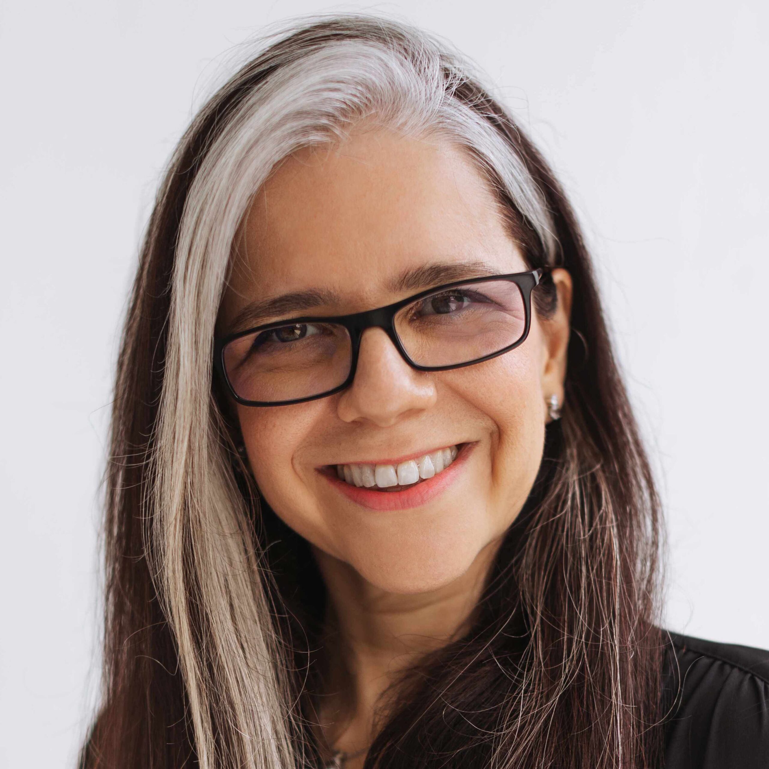 A middle-aged woman with white streaks in her hair. She also has on black spectacles.